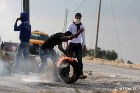 A Palestinian protester burns a tire during minor clashes against Israel's military operation in the Gaza Strip, in the West Bank village of Birzeit, near Ramallah November 19, 2012. Israel bombed dozens of targets in Ga...