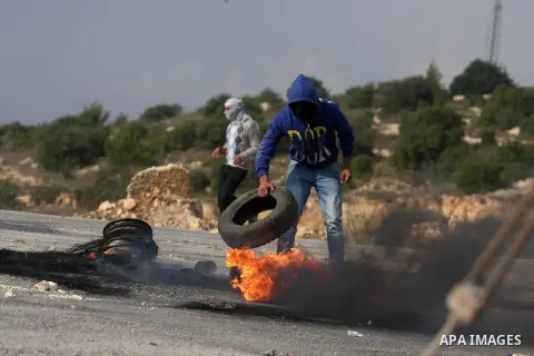 A Palestinian protester burns a tire during minor clashes against Israel's military operation in the Gaza Strip, in the West Bank village of Birzeit, near Ramallah November 19, 2012. Israel bombed dozens of targets in Ga...