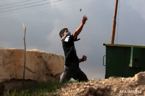 A Palestinian protester throws stones at Israeli security forces during minor clashes against Israel's military operation in the Gaza Strip, in the West Bank village of Birzeit, near Ramallah November 19, 2012. Israel bo...