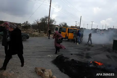 Palestinians run cover from tear gas during minor clashes against Israel's military operation in the Gaza Strip, in the West Bank village of Birzeit, near Ramallah November 19, 2012. Israel bombed dozens of targets in Ga...
