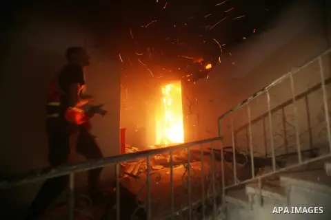 A Palestinian firefighter tries to extinguish a fire after an Israeli air strike on a floor in a building that also houses international media offices in Gaza City November 19, 2012. An Islamic Jihad local commander was...