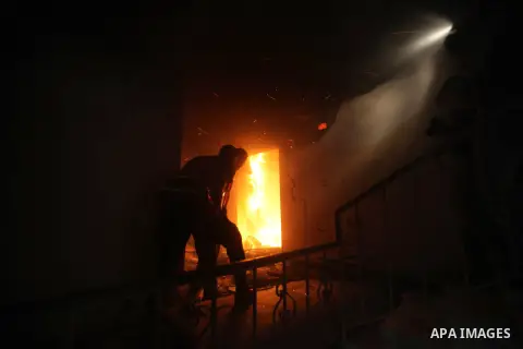 A Palestinian firefighter tries to extinguish a fire after an Israeli air strike on a floor in a building that also houses international media offices in Gaza City November 19, 2012. An Islamic Jihad local commander was...