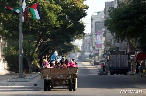 Palestinian families evacuate their homes in the back of trucks following an Israeli air strike in Gaza City, on November 20, 2012. Seven Palestinians were wounded in strikes on Gaza overnight, but no one was killed in t...