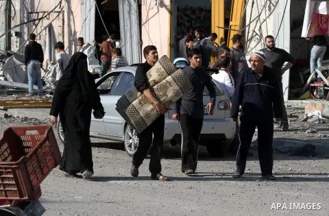 A Palestinian man carry his baggage as he evacuates his home following an Israeli air strike in Gaza City, on November 20, 2012. Seven Palestinians were wounded in strikes on Gaza overnight, but no one was killed in the...