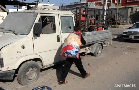 A Palestinian man carry his baggage as he evacuates his home following an Israeli air strike in Gaza City, on November 20, 2012. Seven Palestinians were wounded in strikes on Gaza overnight, but no one was killed in the...