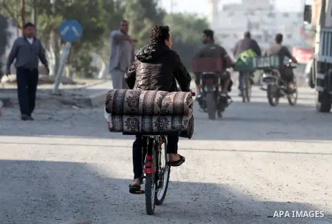 Palestinians carry their baggage on bicycles as they evacuates their homes following an Israeli air strike in Gaza City, on November 20, 2012. Seven Palestinians were wounded in strikes on Gaza overnight, but no one was...