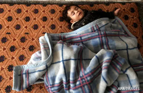 A Displaced Palestinian baby boy from al-Atatra area, whose feld their house, sleeps in a classroom, his temporary residence, at a United Nations-run school in Gaza City, on November 20, 2012. Israeli leaders discussed a...