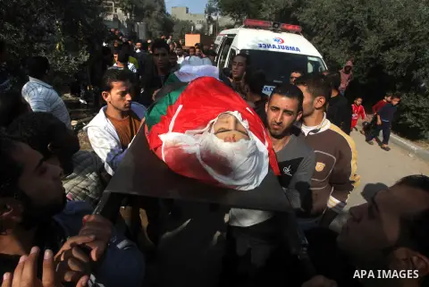 Palestinians carry the body of Osama Shehada, 17, during his funeral in the Nuseirat Refugee Camp, central Gaza Strip, Tuesday, Nov. 20, 2012. Shehada was killed in an Israeli air strike on Monday while walking with his...