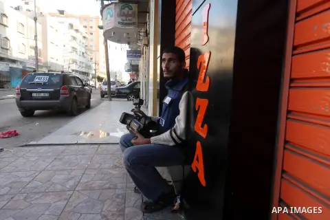 A Palestinian cameraman sits waiting in the street in Gaza city, on November 20, 2012. Two Palestinian journalists were killed in an Israeli airstrike on Gaza City Tuesday evening, after media buildings were hit by Israe...