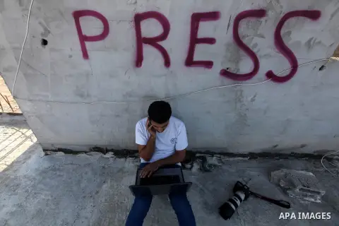 A Palestinian photographer checks his laptop on a building in Gaza city, on November 20, 2012. Two Palestinian journalists were killed in an Israeli airstrike on Gaza City Tuesday evening, after media buildings were hit...