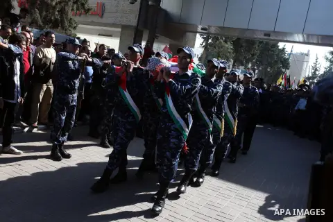 Palestinian policemen carry the body of their comrade Rushdi Tamimi, 31, during his funeral procession in the West Bank city of Ramallah November 20, 2012. amimi was wounded during a protest against Israel's operation in...