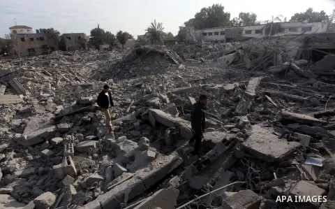 Palestinians look at government offices destroyed in an Israeli airstrike in Gaza City, 21 November 2012. Palestinian militants renewed their rocket fire on Israel 21 November and Israel continued pounding targets in the...