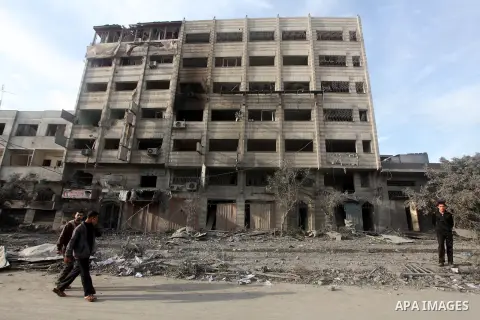 Palestinians look at government offices destroyed in an Israeli airstrike in Gaza City, 21 November 2012. Palestinian militants renewed their rocket fire on Israel 21 November and Israel continued pounding targets in the...