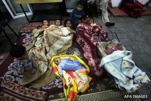Displaced Palestinians from al-Atatra area, whose fled their house, gather in their temporary residence, at a United Nations-run school in Gaza City, on November 21, 2012. Israeli leaders discussed an Egyptian plan for a...