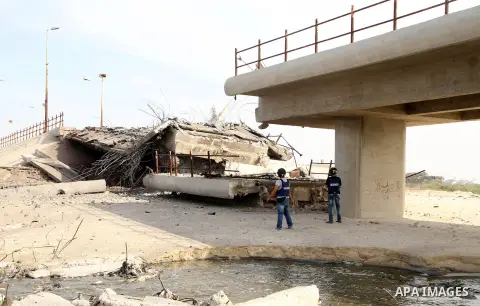 Palestinian photographers stand in front A bridge connecting the north and central part of the Gaza Strip, which was destroyed overnight by an Israeli airstrike in Gaza City, 21 November 2012. Palestinian militants renew...