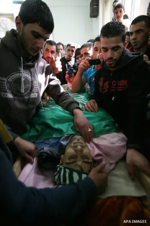 Relatives of Hamdi al Fallah touch his body during his funeral in the West Bank city of Hebron November 20, 2012. Two funeral processions for Palestinians killed during clashes with the Israeli army turned violent on Tue...