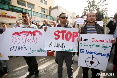 Palestinian Journalists hold placards during a protest against the Israeli targeting the Gazans media members, in the West Bank city of Hebron, November 21, 2012. Two cameramen from Hamas-owned Al-Aqsa TV were among six...