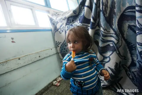 Palestinians gather where displaced families are staying after evacuating their homes earlier this week to take shelter at a United Nations (UN) school in Gaza City on November 21, 2012. Palestinian president Mahmud Abba...