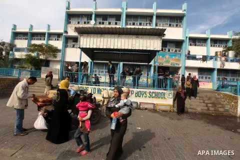 Palestinians gather where displaced families are staying after evacuating their homes earlier this week to take shelter at a United Nations (UN) school in Gaza City on November 21, 2012. Palestinian president Mahmud Abba...