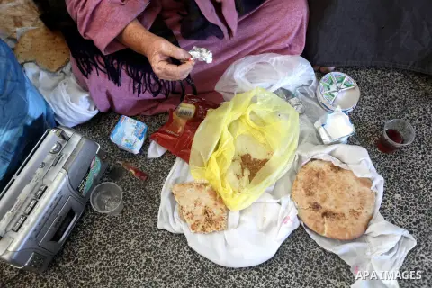 Palestinians gather where displaced families are staying after evacuating their homes earlier this week to take shelter at a United Nations (UN) school in Gaza City on November 21, 2012. Palestinian president Mahmud Abba...