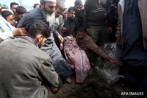A Palestinian man carries the body of Mohammed Ashour, 10, killed the previous day in an Israeli air strike on Gaza City, during his funeral, Wednesday, Nov. 21, 2012. Israeli aircraft pounded Gaza with at least 30 strik...