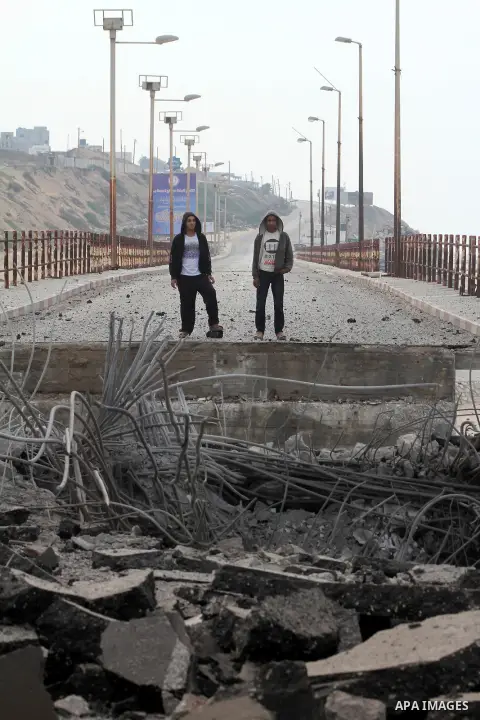 Palestinians look at Wadi Gaza bridge, a strategic link between the northern and southern areas of the Gaza Strip, following an overnight Israeli air strike on November 21, 2012. Today's bloodshed raised to 148 the total...