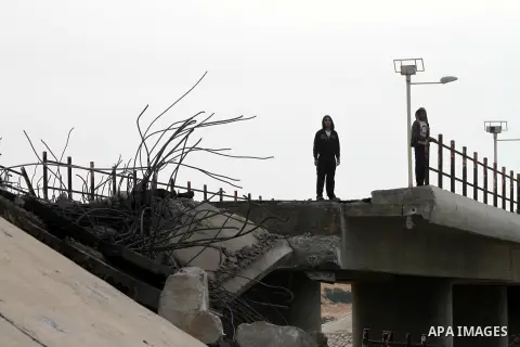 Palestinians look at Wadi Gaza bridge, a strategic link between the northern and southern areas of the Gaza Strip, following an overnight Israeli air strike on November 21, 2012. Today's bloodshed raised to 148 the total...