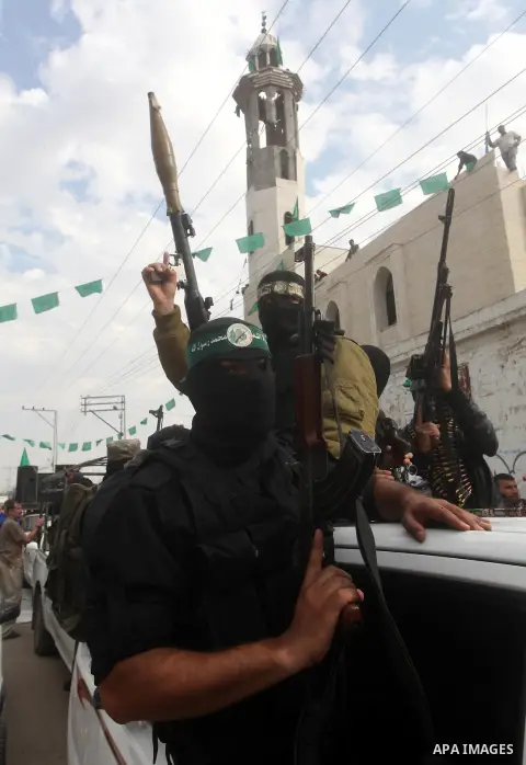 Hamas militants ride in a pick-up truck as they take part in the funeral of their comrades, whom medics said were killed in Israeli air strikes on Wednesday, in the central Gaza Strip November 22, 2012. A ceasefire betwe...