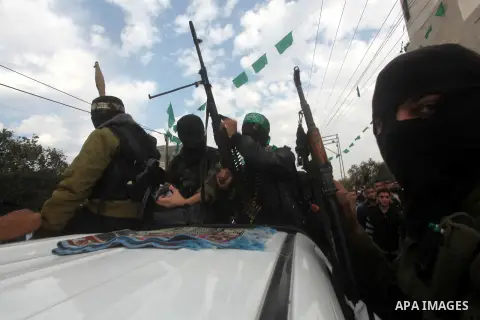 Hamas militants ride in a pick-up truck as they take part in the funeral of their comrades, whom medics said were killed in Israeli air strikes on Wednesday, in the central Gaza Strip November 22, 2012. A ceasefire betwe...