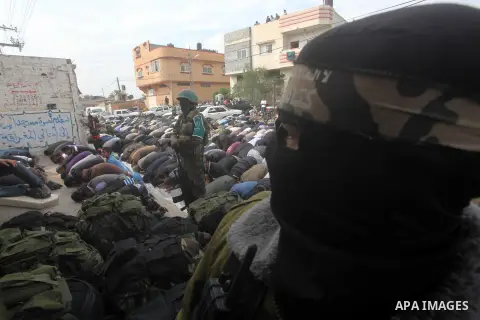Members of the Ezzedine al-Qassam brigades, the armed wing of Hamas, carry their weapons as they celebrate after the truce between Gaza and Israel came into effect, in the Nusseirat refugee camp in the central Gaza Strip...