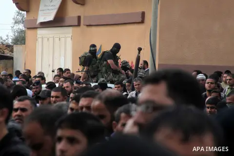 Members of the Ezzedine al-Qassam brigades, the armed wing of Hamas, carry their weapons as they celebrate after the truce between Gaza and Israel came into effect, in the Nusseirat refugee camp in the central Gaza Strip...