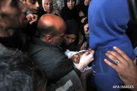A man holds the body of his daughter, three-year-old Reham Al Nabaheen, during her funeral at Al Nusairat refugee camp in central Gaza Strip, 22 November 2012. Reham Al Nabaheen was reportedly killed after an Israeli air...