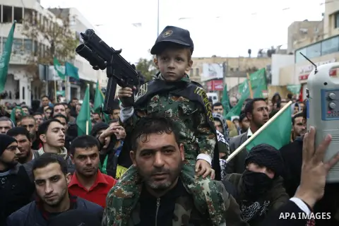 Palestinian supporters of the Islamist movement Hamas gesture and wave the movement's flag during a demonstration in the West Bank city of Hebron on November 23, 2012. Photo by Mamoun Wazwaz
