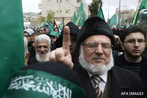 Palestinian supporters of the Islamist movement Hamas gesture and wave the movement's flag during a demonstration in the West Bank city of Hebron on November 23, 2012. Photo by Mamoun Wazwaz