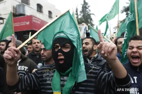Palestinian supporters of the Islamist movement Hamas gesture and wave the movement's flag during a demonstration in the West Bank city of Hebron on November 23, 2012. Photo by Mamoun Wazwaz
