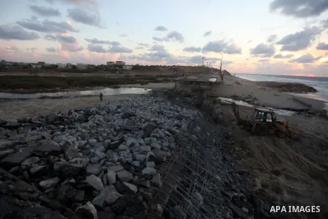 Palestinians look at Wadi Gaza bridge, a strategic link between the northern and southern areas of the Gaza Strip, following an Israeli air strike, November 23, 2012. Palestinians and Israelis on both sides of the Gaza b...