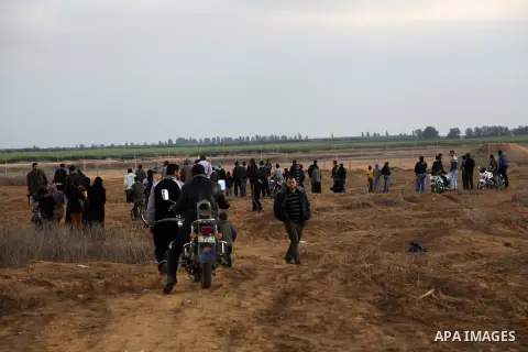 Palestinians stand near the Israeli Gaza border fence in east of Khan Younis, southern Gaza Strip, Friday, Nov. 23, 2012. Hundreds of Gaza crowds surged toward Israel's border fence with the Hamas-ruled territory, in a n...
