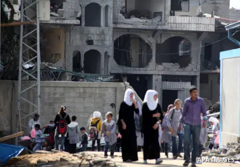 Palestinians school girls walk on the rubble of a building destroyed during earlier Israeli bombardment, as they make their way to their nearby school in Gaza City, on November 24, 2012, three days after a truce was decl...