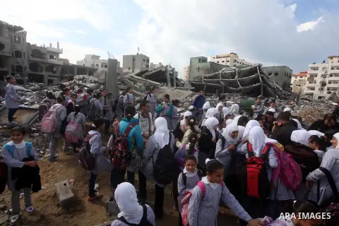 Palestinians school girls walk on the rubble of a building destroyed during earlier Israeli bombardment, as they make their way to their nearby school in Gaza City, on November 24, 2012, three days after a truce was decl...