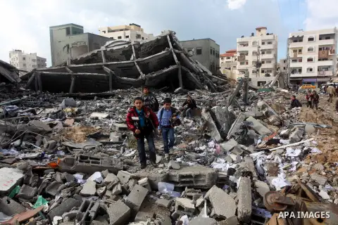 Palestinians school girls walk on the rubble of a building destroyed during earlier Israeli bombardment, as they make their way to their nearby school in Gaza City, on November 24, 2012, three days after a truce was decl...