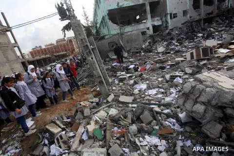 Palestinians school girls walk on the rubble of a building destroyed during earlier Israeli bombardment, as they make their way to their nearby school in Gaza City, on November 24, 2012, three days after a truce was decl...