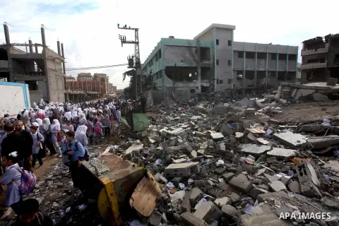 Palestinians school girls walk on the rubble of a building destroyed during earlier Israeli bombardment, as they make their way to their nearby school in Gaza City, on November 24, 2012, three days after a truce was decl...