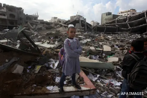 Palestinians school girls walk on the rubble of a building destroyed during earlier Israeli bombardment, as they make their way to their nearby school in Gaza City, on November 24, 2012, three days after a truce was decl...