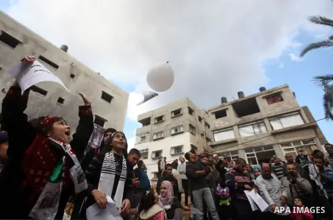 Palestinians release balloons at the site of the destroyed house of the Dalou family in Gaza City November 24, 2012. Eleven members of the Dalou family were killed after an Israeli air strike on their house during the ei...