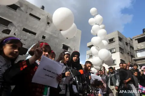 Palestinians release balloons at the site of the destroyed house of the Dalou family in Gaza City November 24, 2012. Eleven members of the Dalou family were killed after an Israeli air strike on their house during the ei...
