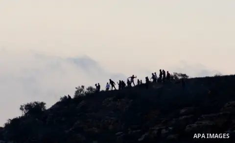 Palestinians take cover amongst trees during clashes with Israeli soldiers after Israeli settlers attacked villagers in the northern West Bank village of Qusra on November 24, 2012. Photo by Nedal Eshtayah