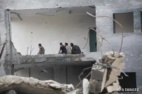 Employees of the Palestinian Interior ministry pray in the rubble of the Interior Ministry building in Gaza City on November 25, 2012, days after a truce between Hamas and Israel, ended eight days of cross border attacks...