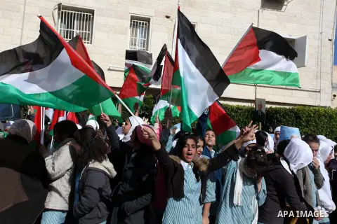 Palestinians hold posters of Palestinian President Mahmoud Abbas during a rally supporting the Palestinian UN bid for observer state status, in the West Bank city of Ramallah, Sunday, Nov. 25, 2012. The Palestinians will...
