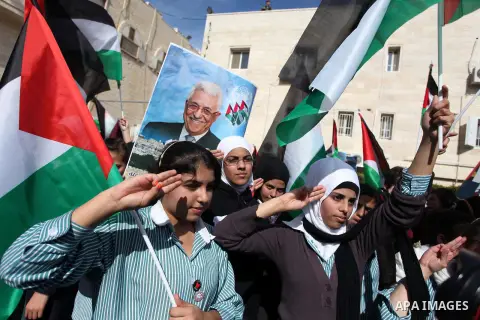 Palestinians hold posters of Palestinian President Mahmoud Abbas during a rally supporting the Palestinian UN bid for observer state status, in the West Bank city of Ramallah, Sunday, Nov. 25, 2012. The Palestinians will...