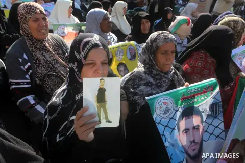 Palestinian women hold a poster of Palestinian prisoners during a protest calling for the release them from Israeli jails and in support of prisoners on hunger strike in front of Red Cross, in Gaza city on 26 November 20...